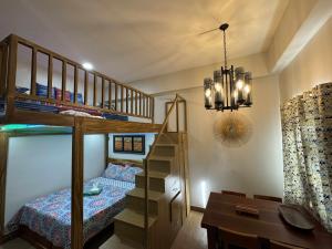 a bedroom with a bunk bed and a desk at Happy Stays C - 300mbps - 65"TV NetFlix, Disney - Loft in Trece Martires