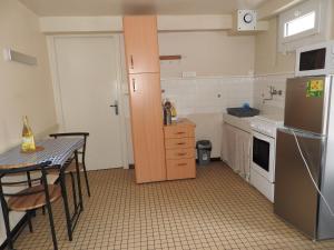 a small kitchen with a table and a refrigerator at Appartement Erable-Résidence Les Glycines in Eugénie-les-Bains