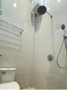 a bathroom with a shower with a toilet in it at Kuara Guest House Bebesen in Takengon