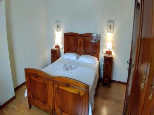 a bedroom with a wooden bed and two night stands at Holiday Home for Families in Umbrian in Ramazzano