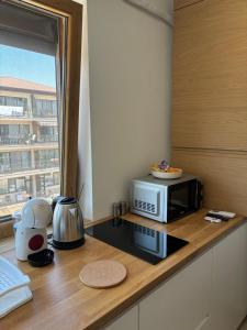 a kitchen with a microwave on a counter with a window at La Dolce Riva Apartments - Navodari Mamaia-Sat in Mamaia Nord