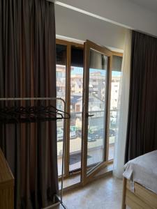 a bedroom with a balcony with a view of a city at La Dolce Riva Apartments - Navodari Mamaia-Sat in Mamaia Nord
