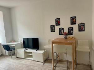 a room with a desk with a television and a table with chairs at Bike & Relax in Bernburg