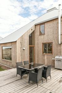 a patio with a table and chairs on a wooden deck at Kivikshusen in Kivik
