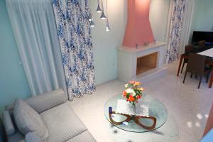 a living room with a table with flowers on it at Villa Eudora Nafpaktos in Nafpaktos +42 photos