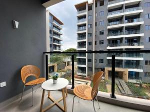 a balcony with chairs and a table and a large window at The Garden Nook in Dar es Salaam