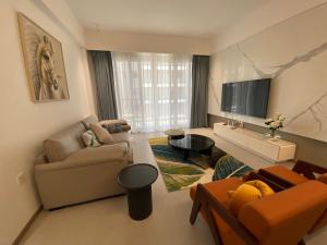 a living room with a couch and a tv at The Garden Nook in Dar es Salaam
