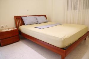 a bed in a bedroom with a wooden bed frame and a nightstand at Villa Eudora Nafpaktos in Nafpaktos