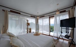 a bedroom with two beds and large windows at The heaven villa in Ban Mae Ta Man