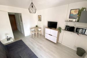 a living room with a small table and a television at Apartment on the Port of Carnon in Mauguio