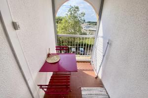 a balcony with a purple table and chairs on it at Apartment on the Port of Carnon in Mauguio