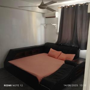 un lit dans une chambre avec un canapé noir dans l'établissement Le magashi, à Grand Baie