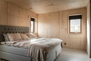 a bedroom with a bed and two windows at Kivikshusen in Kivik