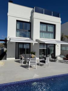 ein weißes Haus mit einem Swimmingpool davor in der Unterkunft Villa Mirasol - mountain-, sea view, roof terrace, private pool in Mutxamel