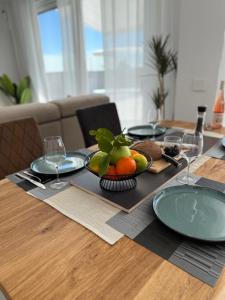 ein Tisch mit einer Obstschale und Tellern darauf in der Unterkunft Villa Mirasol - mountain-, sea view, roof terrace, private pool in Mutxamel