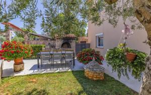 a patio with a table and chairs and flowers at Ferienhaus mit Privatpool für 13 Personen ca 192 qm in Peroj, Istrien Istrische Riviera in Peroj