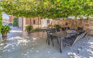 a patio with a table and chairs under a tree at Ferienhaus mit Privatpool für 13 Personen ca 192 qm in Peroj, Istrien Istrische Riviera in Peroj
