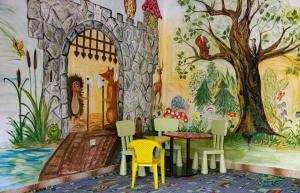 a room with a mural of a tree and chairs at Garden Szálláshely in Balatonszemes