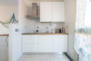 a kitchen with white cabinets and a sink at Mare fuori in Villasimius