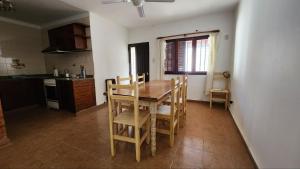 a kitchen with a wooden table and chairs in it at La casa de la abu in Carmen de Areco