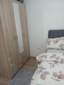 a bedroom with a bed and a mirror next to a door at Aprtman SALE in Vrnjačka Banja