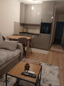 a living room with a couch and a table and a kitchen at Aprtman SALE in Vrnjačka Banja