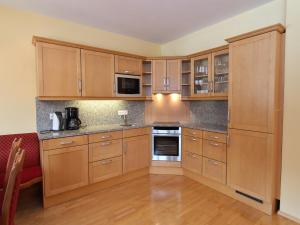 a kitchen with wooden cabinets and a stove top oven at Chalet in Saalbach near Ski Lift in Saalbach Hinterglemm