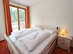 a white bed in a room with a window at Detached Chalet in Saalbach in Saalbach-Hinterglemm