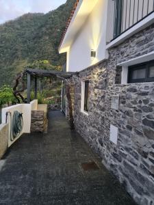 a stone house with a pathway leading up to a building at casa Farraia in Santana