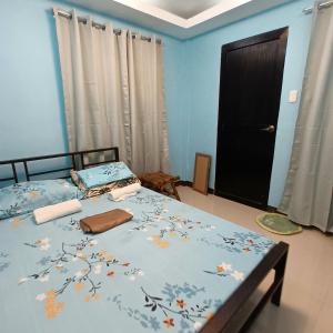 une chambre avec deux lits avec des murs bleus et une porte noire dans l'établissement Villa Catalina Leisure resort, à Nabas