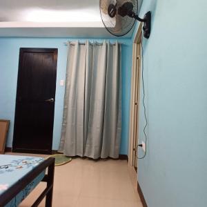 Cette chambre dispose d'une porte et d'un ventilateur mural. dans l'établissement Villa Catalina Leisure resort, à Nabas