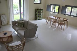Una sala de estar con un sofá, una mesa y sillas. en Sogno delle Api Lavanda, en Belvedere Ostrense