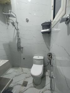 a white bathroom with a toilet and a shower at فندق نسيم الربيع in Muhayil +11 photos