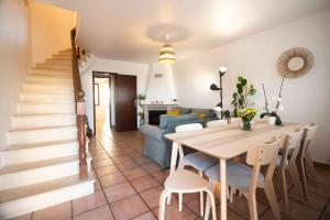 a living room with a table and a blue couch at Baleal Beach Haven - Surf, Sun & Sea in Ferrel