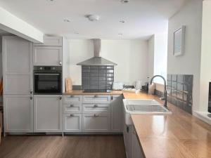 a kitchen with white cabinets and a stove top oven at Holiday House at 22, 3 bedroom cottage in historic Wigtown in Wigtown +20 photos