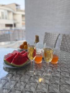 einen Tisch mit zwei Gläsern Wein und einem Teller Wassermelone in der Unterkunft Золотой Бугаз Грибовка апартаменты 169  + 41 Fotos