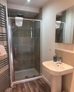a bathroom with a glass shower and a sink at Holiday House at 22, 3 bedroom cottage in historic Wigtown in Wigtown