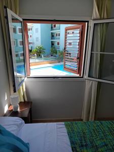 a bedroom with a view of a pool from a window at Charming 3 Bedroom Apartment in Puerto Sotogrande in Torreguadiaro +33 photos