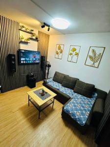 una sala de estar con un sofá y una mesa en Reyes Haven - Urban Deca Marilao, en Marilao