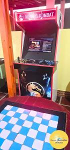 ウバトゥバにあるPousada Gaivotas de Marandubaのチェッカーボード模様の床の部屋にあるビデオゲーム機