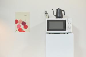 東京にあるThe underz suite residence Ikebukuroの冷蔵庫の上に置かれた電子レンジ +89枚の写真