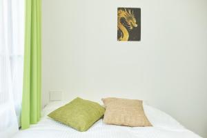 東京にあるThe underz suite residence Ikebukuroのベッド(緑と白のシーツ、枕付)