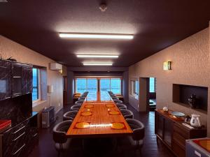 a long table in a room with chairs and a long table at Moonbay Beach Villa in Lake Toya
