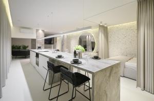 a kitchen and living room with a large island with chairs at Provokatas in Kaunas