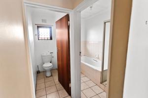a bathroom with a toilet and a bath tub at Home in Beacon Bay in East London +29 photos