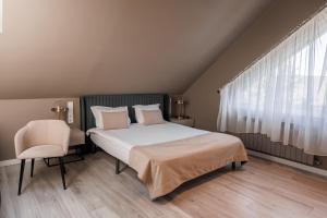 a bedroom with a bed and a chair and a window at R.HOTEL in Chernivtsi +54 photos