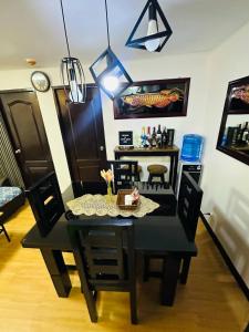 ein Esszimmer mit einem schwarzen Tisch und Stühlen in der Unterkunft Reyes Haven - Urban Deca Marilao in Marilao + 3 Fotos