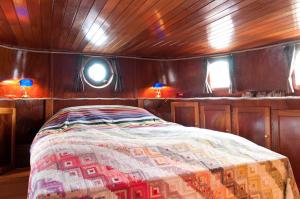 un dormitorio en un barco con una cama en él en art deco houseboat on super location, en Ámsterdam