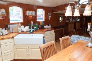 Una cocina con fregadero y una mesa con sillas. en art deco houseboat on super location, en Ámsterdam