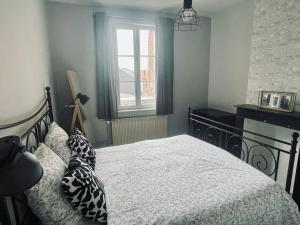 a bedroom with a bed and a window at Appartement 80m2 à deux pas du beffroi in Arras